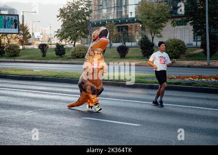 Kazakistan, Almaty-25 settembre 2022: Maratona di Almaty. La gente corre lungo un ampio viale Foto Stock