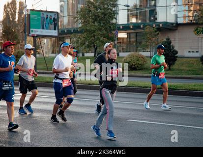 Kazakistan, Almaty-25 settembre 2022: Maratona di Almaty. La gente corre lungo un ampio viale Foto Stock