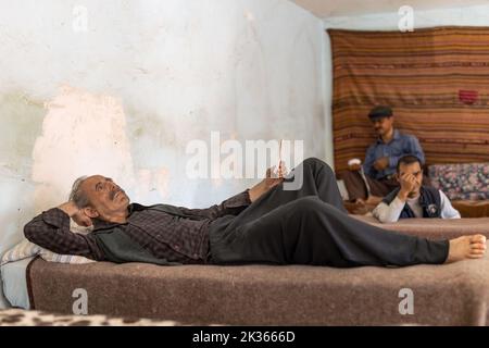 Antalya, Turchia-23 settembre 2022: Scultura in cera di un vecchio prigioniero che legge la lettera mentre sdraiato sulla cuccetta nel Museo della prigione di Ulucanlar. Foto Stock