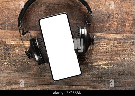 moderno telefono cellulare con schermo bianco per l'inserimento di un'iscrizione o logo con cuffie senza fili isolate su sfondo bianco, vuoto per desi Foto Stock