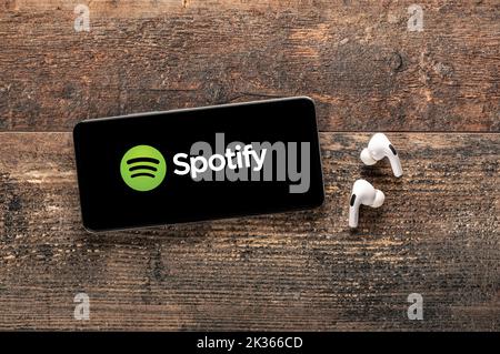 USA, NEW YORK 22 settembre 2022: Applicazione mobile con logo Spotify sullo schermo del cellulare sul vecchio tavolo di legno. Servizio di streaming audio e musica Spotify. Spotify Foto Stock