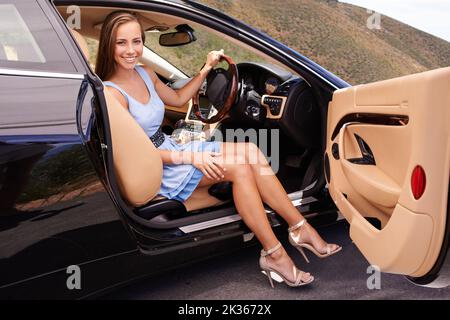 Im a casa dietro il volante. Una donna seduta in un'auto di lusso. Foto Stock