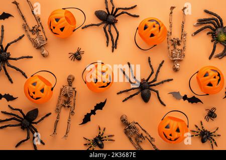 Decorazioni di Halloween, zucche, scheletri, pipistrelli, ragni su sfondo arancione Foto Stock