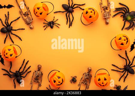 Decorazioni di Halloween, zucche, scheletri, pipistrelli, ragni su sfondo arancione Foto Stock