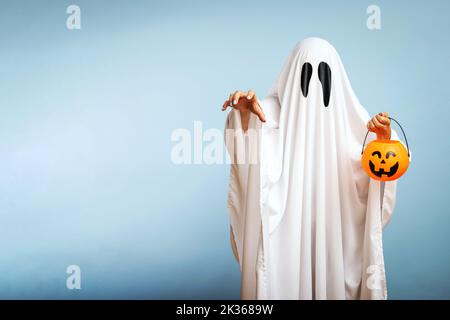 Un fantasma bianco con occhi neri, fatto da un lenzuolo con cesto di zucca Foto Stock