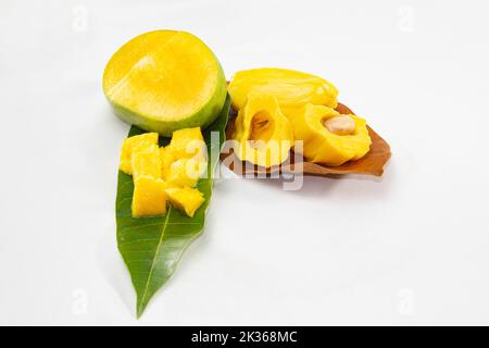 Jackfruit e mango tagliati sulle foglie. Frutta tropicale estiva in Asia. Foto isolata in studio. Rinfrescante insalata di frutta calda per il giorno. Foto Stock