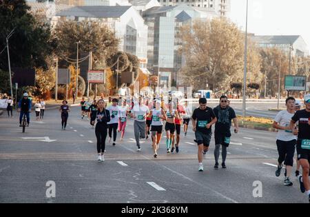 Kazakistan, Almaty-25 settembre 2022: Maratona di Almaty. La gente corre lungo un ampio viale Foto Stock