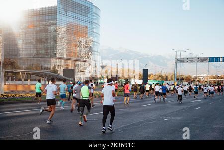 Kazakistan, Almaty-25 settembre 2022: Maratona di Almaty. La gente corre lungo un ampio viale Foto Stock