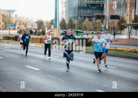 Kazakistan, Almaty-25 settembre 2022: Maratona di Almaty. La gente corre lungo un ampio viale Foto Stock