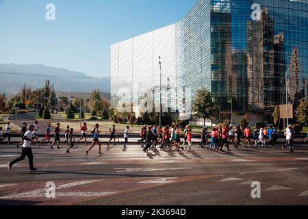 Kazakistan, Almaty-25 settembre 2022: Maratona di Almaty. La gente corre lungo un ampio viale Foto Stock