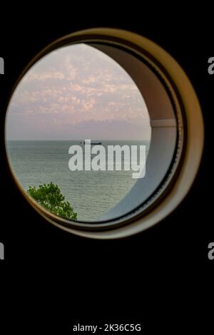Una vista dalla finestra oblò di una nave da crociera, che mostra una nave Foto Stock
