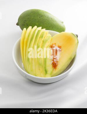 una fettina di mango e di mango sbucciata con sale e peperoncino in polvere. frutta acida e dolce rinfrescante in estate. Foto Stock