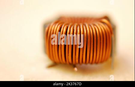 Una bobina in rame isolata, componente induttivo che immagazzina energia come campo magnetico per induzione Foto Stock