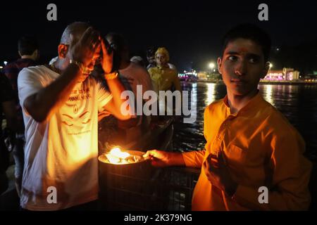 23 settembre 2022, Rishikesh, Uttarakhand, India: Un giovane rishikumar tiene il piatto di Aarti per i devoti che prendono le benedizioni come parte del rituale. Parmarth Niketan fondata nel 1942 da Pujya Swami Sukhdevanandji Maharaj è il più grande ashram di Rishikesh, con oltre 1000 camere che forniscono un'atmosfera pulita, pura e sacra con abbondanti e bei giardini a migliaia di pellegrini che provengono da tutti gli angoli della Terra. Le attività quotidiane al Parmarth Niketan includono yoga quotidiano specializzato in Vinyasa Yoga, Hatha yoga generale, yoga Nindra, preghiere universali mattutine e lezioni di meditazione, dail Foto Stock