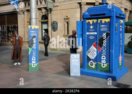 Buchanan St, Glasgow, Scozia, Regno Unito. Scatola di polizia dipinta in blu originale. Ora convertito in una piccola unità di vendita al dettaglio che vende oli CBD concentrati Edibles. I dispensari originali di CBDtec Scotland. L'uomo vicino alla cannabis Trades Association.Man sembra l'attore scozzese David Tennant vestito come Dr Who Foto Stock