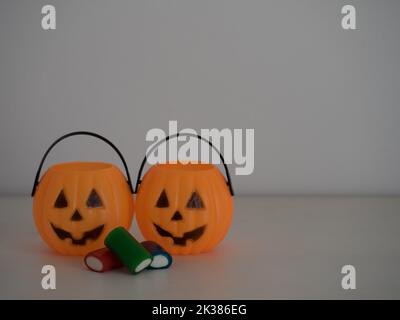 fondo bianco con caramelle all'interno di zucche di halloween Foto Stock