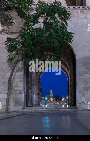 Vista dall'interno dell'arco della porta Serrano, che si affaccia sul ponte, con un campanile sullo sfondo Foto Stock