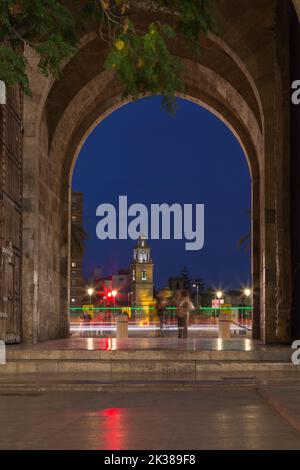 Vista dall'interno dell'arco della porta Serrano, che si affaccia sul ponte, con un campanile sullo sfondo Foto Stock