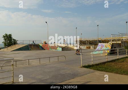 BATUMI, GEORGIA, AJARIA - 29 AGOSTO 2022: I bambini cavalcano skateboard e scooter in un parco giochi speciale. Il concetto di sport e intrattenimento. Foto Stock