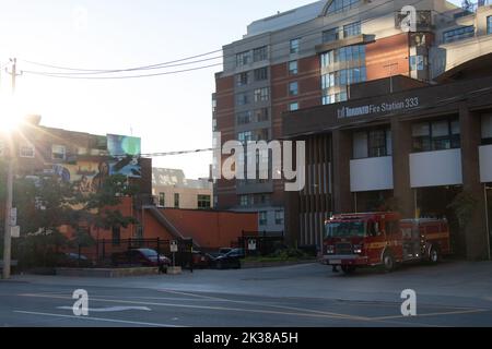 La mattina sfreccia su una stazione dei vigili del fuoco di Toronto, mentre un camion dei vigili del fuoco è visto parcheggiato davanti al centro di Toronto. Foto Stock