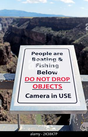 A circa 600 metri sopra il Rio grande, il ponte ad arco in acciaio vicino a Taos, New Mexico, ha un cartello di avvertimento sulla caduta di oggetti sotto. Foto Stock