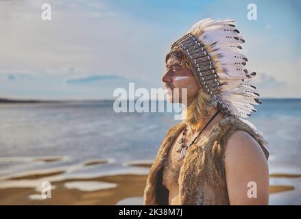 Uomo in abiti tradizionali nativi americani vicino al mare Foto Stock