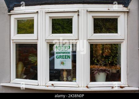 Tilehurst, Regno Unito. 25th Settembre 2022. Nella finestra di una casa è raffigurato un manifesto verde del Keep Kentwood. Kentwood Green è un'area boschiva ricca di fauna selvatica, tra Armour Hill e Kentwood Hill, attualmente minacciata da lavori di indagine e da potenziali sdoganamenti. È di proprietà di Tilehurst Poor's Land Charity (TPLC) e parte del sito è stata destinata all'edilizia abitativa. I residenti locali e i detentori dell'assegnazione che lottano come Keep Kentwood Green affinchè la terra sia protetta dallo sviluppo dichiarano che la presenza di tassi, volpi, vermi lenti, cervi muntjac e aquilone rosso è stata registrata al luogo. Credi Foto Stock