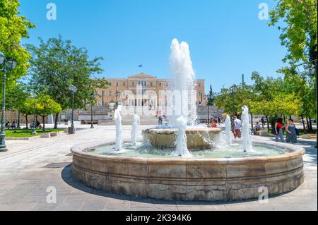 Fontana in piazza Syntagma e il parlamento greco ad Atene in una giornata estiva Foto Stock