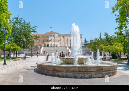 Fontana in piazza Syntagma e il parlamento greco ad Atene in una giornata estiva Foto Stock