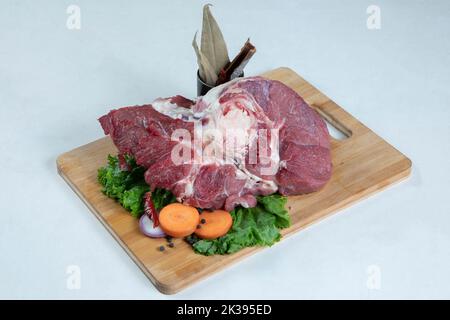 Bistecca di manzo crudo con rosmarino e spezie su tavola di legno Foto Stock