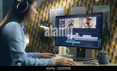 Donna asiatica nella modifica di cuffie video con astronauti per il cliente in programma sul personal computer mentre lavora al tavolo da casa ufficio. Freelance Foto Stock