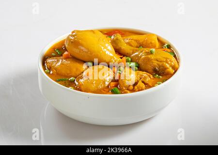 Curry di pollo in ciotola bianca su fondo bianco Foto Stock