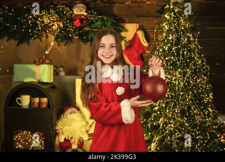 Servizi di noleggio decorazioni. Buona infanzia. La bambina festeggia il natale. Affitto di accessori per le vacanze. Concetto di vacanze invernali. Festeggia il nuovo anno Foto Stock