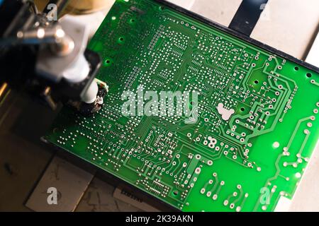 Vista dall'alto di una macchina erogatrice di pasta saldante professionale. Metodo perfetto per saldare componenti SMD multipin. PCB verde. Foto di alta qualità Foto Stock