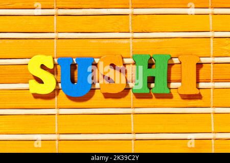 Sushi parola - Iscrizione da lettere colorate su tappeto di bambù Foto Stock