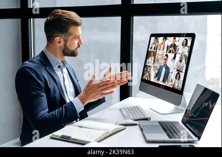 Vista laterale ad un uomo riuscito, capo dell'azienda, investitore azionario, avendo brainstorming finanziario con il gruppo della gente multirazziale dalla video conferenza, discuta gli investimenti nel mercato azionario, rischi Foto Stock