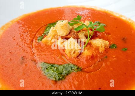 Un piatto tradizionale di cucina spagnola e italiana è la zuppa di pomodoro con crostini e pesto su un piatto. Foto Stock