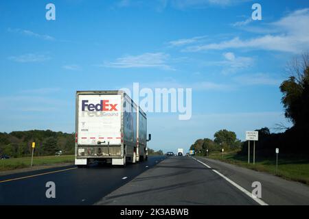 Genesee County, New York, USA - 21 settembre 2022: Un semirimorchio terrestre FedEx guida lungo la sezione New York Thruway dell'Interstate 90. Foto Stock