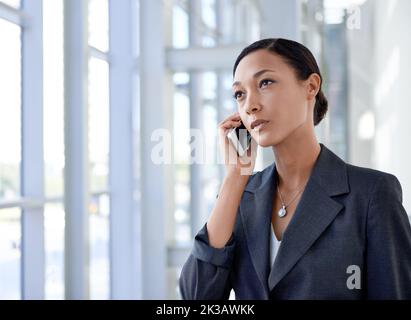 Shes sempre su chiamata. Una donna d'affari etnica che parla su un cellulare. Foto Stock