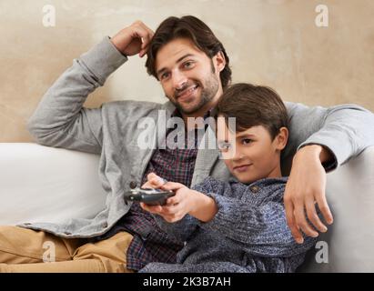 Due patate del divano che si legano. padre e figlio che godono un certo tempo di qualità insieme. Foto Stock