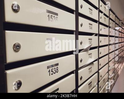 File di cassette postali nella hall di un edificio di appartamenti, Un sacco di cassette postali con numeri di appartamenti Foto Stock