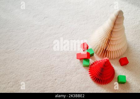 Carta-tress in rosso e verde. Sono collocati su un tappeto di lana bianca. Foto Stock