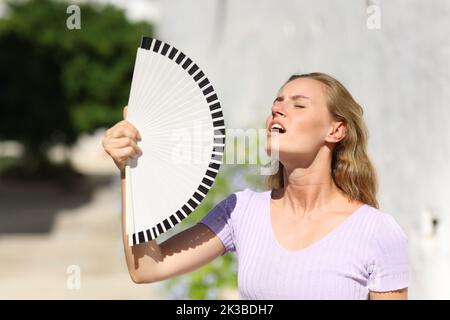 Donna stressata che soffre colpo di calore in estate in una città Foto Stock