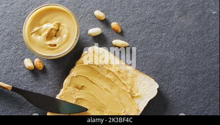 Immagine di primo piano del pane tostato con burro di arachidi su sfondo grigio Foto Stock