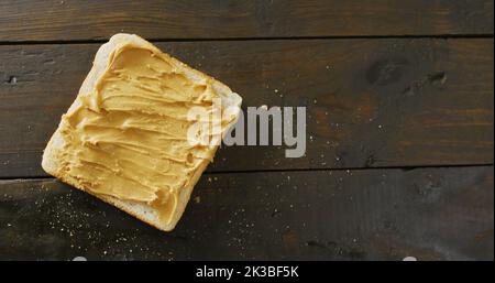 Immagine di primo piano di pane tostato con burro di arachidi su sfondo di legno Foto Stock