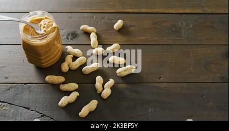 Immagine di primo piano di burro di arachidi su sfondo di legno Foto Stock
