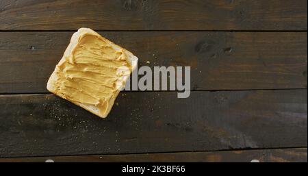 Immagine di primo piano di pane tostato con burro di arachidi su sfondo di legno Foto Stock