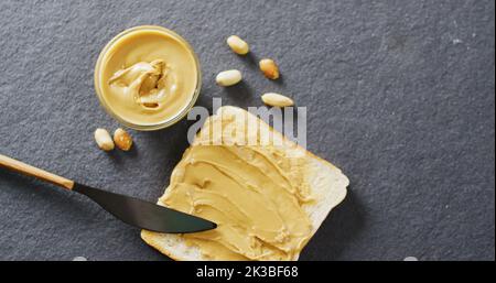 Immagine di primo piano del pane tostato con burro di arachidi su sfondo grigio Foto Stock