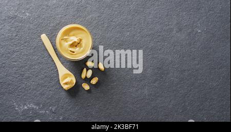 Immagine di primo piano del burro di arachidi su sfondo grigio Foto Stock