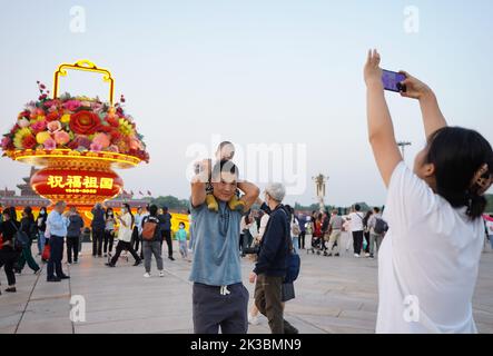 Pechino, Cina. 25th Set, 2022. I turisti posano per le foto di fronte a un 'cesto di fiori' in Piazza Tian'anmen a Pechino, capitale della Cina, 25 settembre 2022. L'esposizione alta 18 metri a forma di cesto di fiori è collocata in Piazza Tian'anmen come decorazione per la prossima festa della Giornata Nazionale. Credit: Chen Zhonghao/Xinhua/Alamy Live News Foto Stock